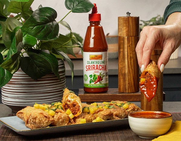 An al pastor egg rolls recipe filled with an al pastor style ground pork, Oaxaca cheese, and served with cilantro lime sriracha for dipping.