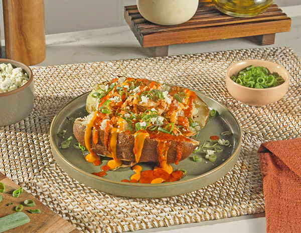 A simple buffalo chicken recipe topping a loaded baked potato.