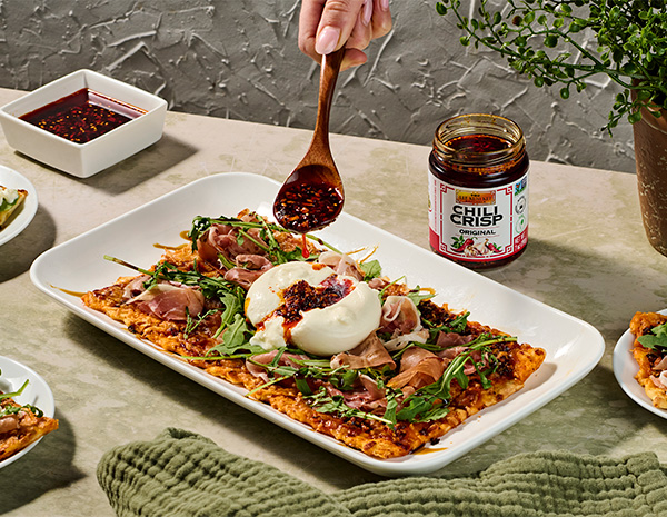 A burrata with prosciutto flatbread recipe topped with original chili crisp.