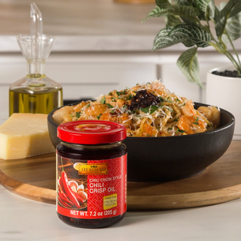 A plate of creamy Chili Oil Caramelized Onion Pasta topped with shrimp and Lee Kum Kee Chiu Chow Style Chili Crisp Oil.