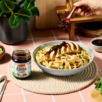 A chipotle chicken alfredo pasta recipe topped with cilantro chili crisp.