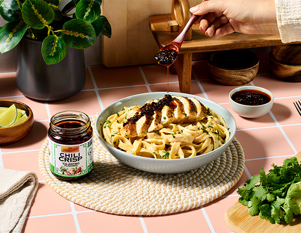 A chipotle chicken alfredo pasta recipe topped with cilantro chili crisp.