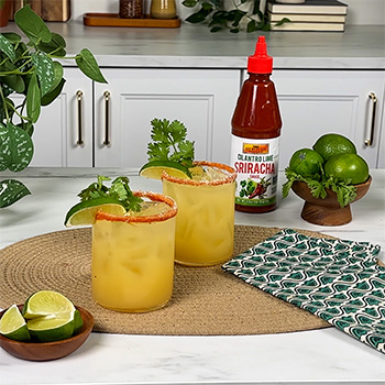 A mocktail recipe for a cilantro lime margarita, made with a cilantro lime sriracha rim.