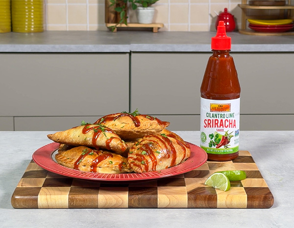 A recipe for Colombian empanadas filled with beef and potato and drizzled with cilantro lime sriracha.