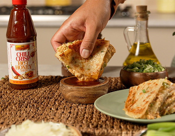 A crab rangoon quesadilla recipe made with scallion pancakes and served with chili crisp hot honey for dipping.