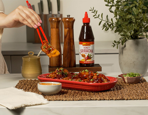 A crispy chicken dumplings recipe coated in a honey buffalo sauce and served with a ranch sriracha mayo dip.