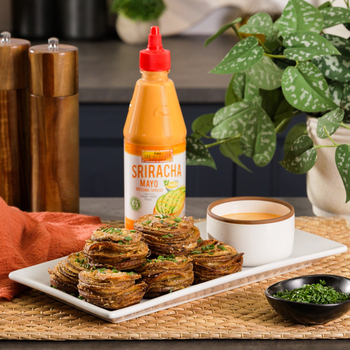 A plate of crispy Parmesan Potato Stacks with a side of Lee Kum Kee Sriracha Mayo for dipping.