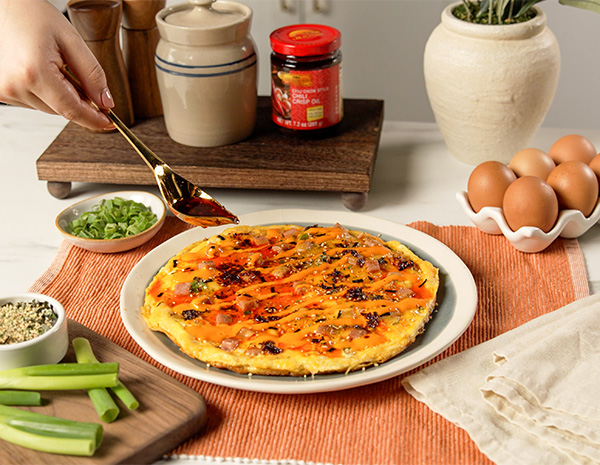 A crispy rice omelette recipe topped with furikake, spam, and chili crisp oil.