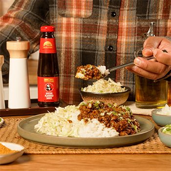 A curry rice bowl recipe made with ground pork for easy meal prep, served with lightly dressed cabbage on the side.