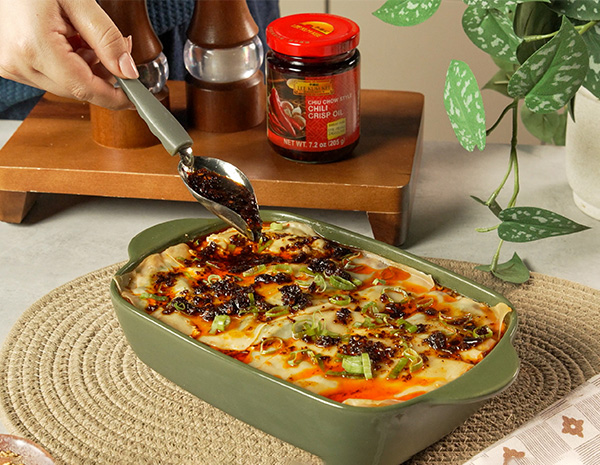 A dumpling lasagna recipe with a mapo tofu inspired filling, topped with chili crisp oil.