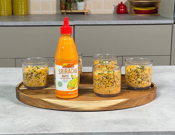 A recipe for esquites, a Mexican street corn recipe made with sriracha mayo and served in cups.