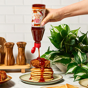 A brunch recipe featuring fried chicken and fluffy pancakes with chili crisp hot honey.
