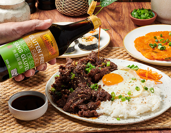 A gluten free bulgogi recipe served on a plate of rice, egg, and veggies.