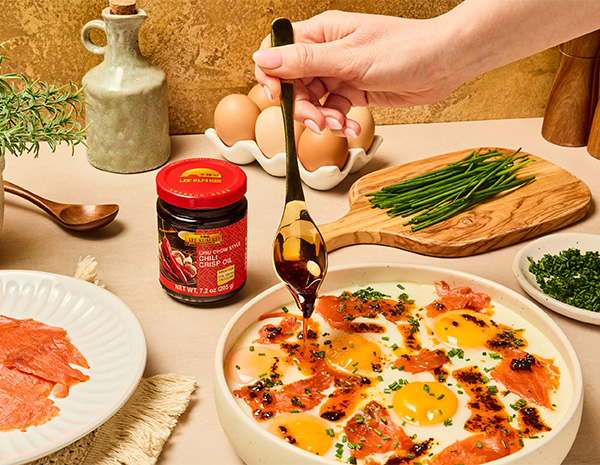 A golden steamed egg recipe topped with smoked salmon, chives, and chili crisp oil.