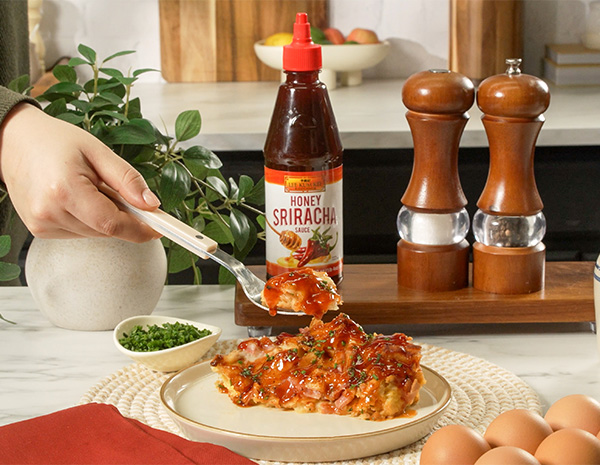 A croissant bake recipe made with ham, Swiss cheese, and sriracha sauces.