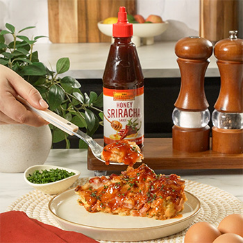 A croissant bake recipe made with ham, Swiss cheese, and sriracha sauces.