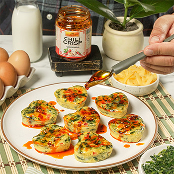 A heart shaped egg bites recipe topped with Chili Crisp for a Mother's Day brunch.