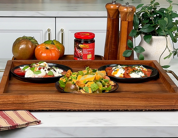 An heirloom tomato flight with a Caprese inspired tomato, a spicy Caesar tomato salad, and a whipped ricotta and hot honey tomato.