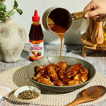 A hot honey butter chicken wings recipe coated in a glaze made with butter and honey sriracha sauce.