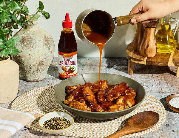 A hot honey butter chicken wings recipe coated in a glaze made with butter and honey sriracha sauce.