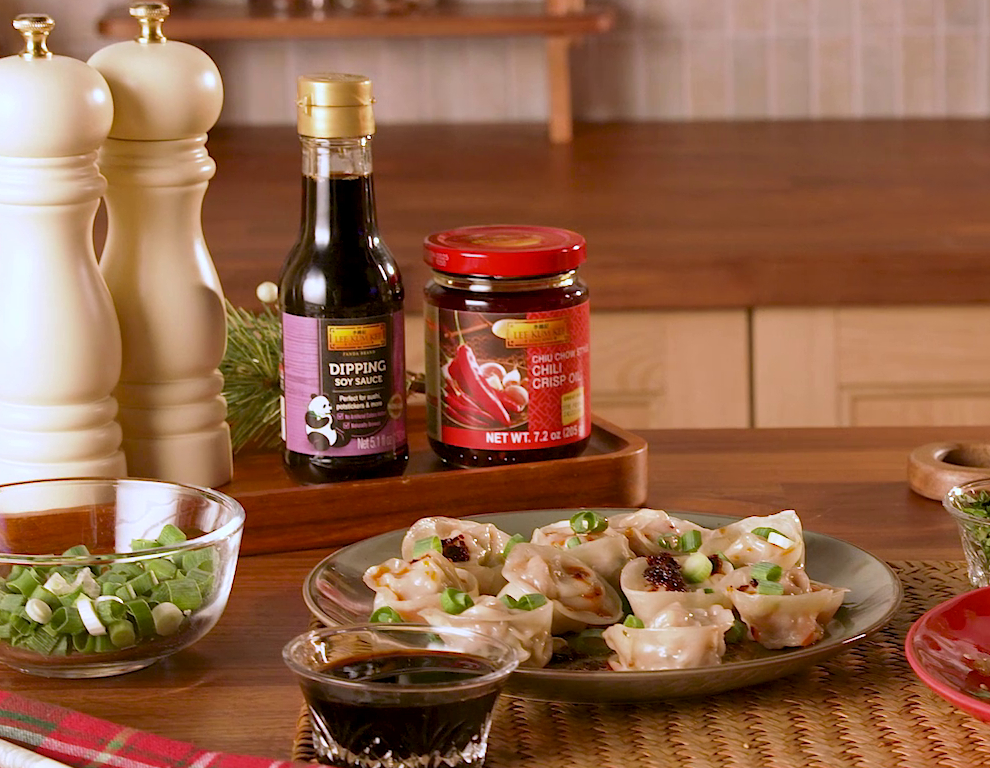 A Pork and Cabbage Dumplings recipe batch for a crowd, served with Lee Kum Kee Chiu Chow Style Chili Crisp Oil for dipping.