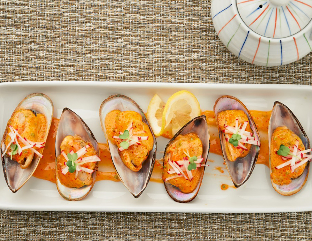 Six baked mussels on half shells with Lee Kum Kee Sriracha Mayo, plated as part of an easy baked mussels recipe
