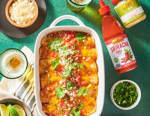 Prepared black bean enchilada recipe in a casserole dish, alongside toppings and the Lee Kum Kee sauces used in the dish.