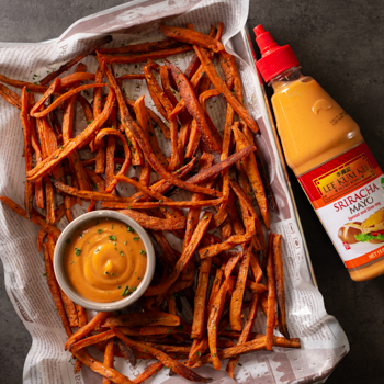 A dozen spicy cheeseburger sliders on a plate with curly fries, made using the recipe for cheeseburger sliders with Lee Kum Kee Chili Garlic Sauce.