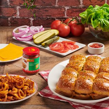 A dozen spicy cheeseburger sliders on a plate with curly fries, made using the recipe for cheeseburger sliders with Lee Kum Kee Chili Garlic Sauce.