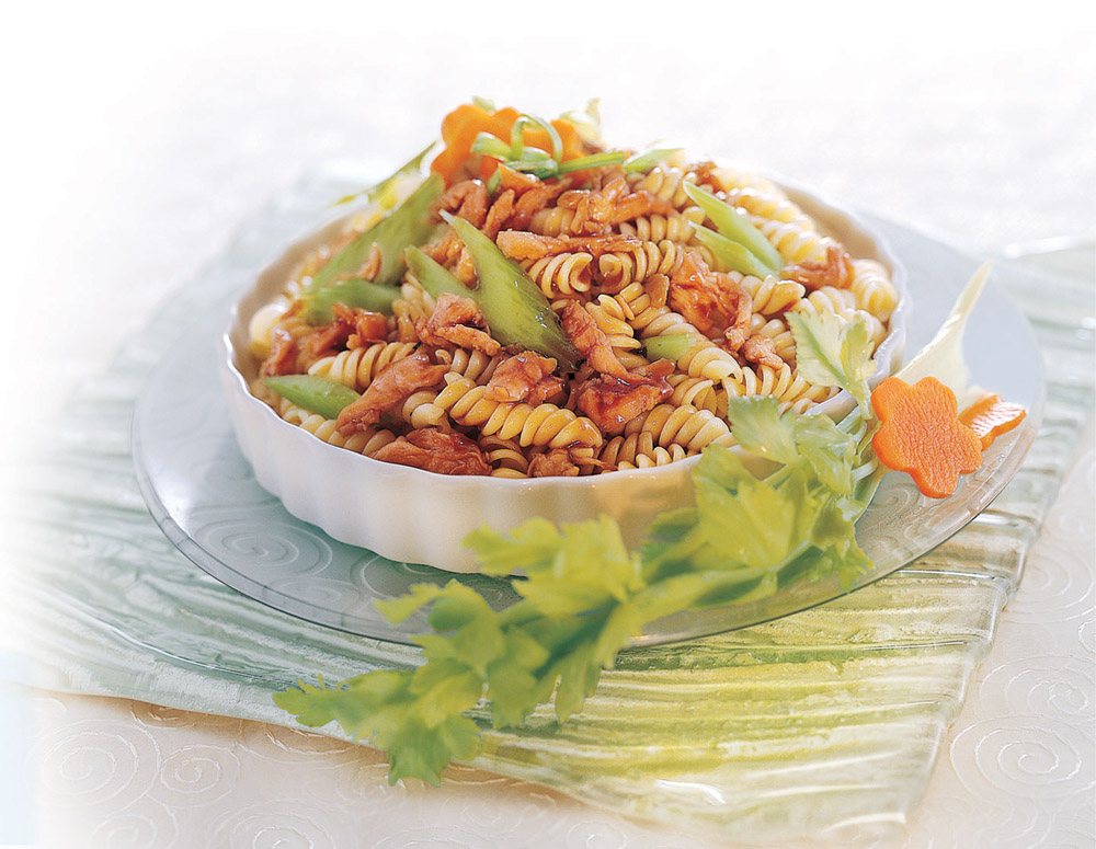 Stir-Fried Pasta spirals served in a fancy dish and garnished with fresh herbs