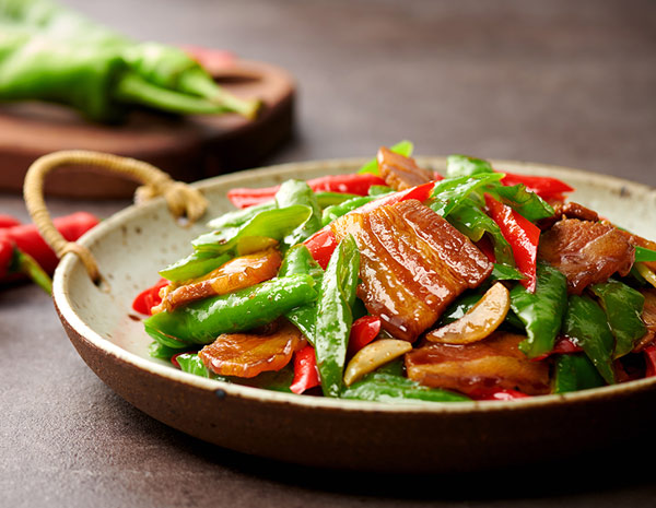 Stir-Fried Pork Belly with Chili Peppers dish served on a rustic plate