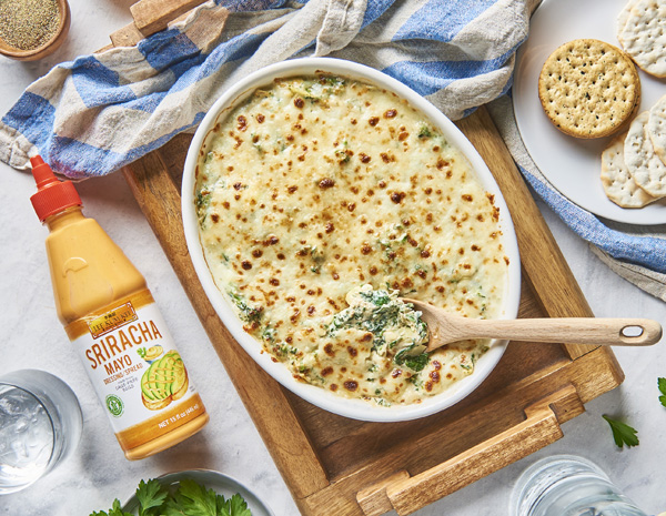 Casserole dish with prepared spinach and artichoke dip from Lee Kum Kee’s easy spinach and artichoke dip recipe.
