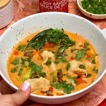 A red curry wonton soup recipe for an easy weeknight dinner, seasoned with soy sauce and chili crisp.