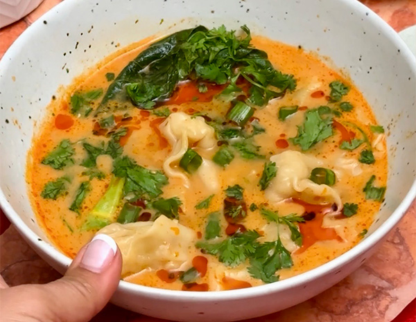 A red curry wonton soup recipe for an easy weeknight dinner, seasoned with soy sauce and chili crisp.