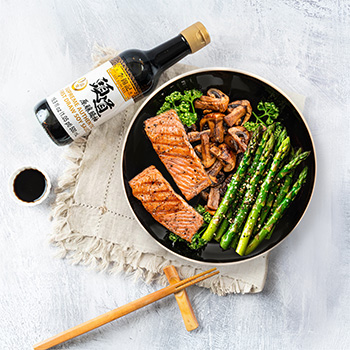 A soy sauce salmon recipe of salmon filets and mushrooms cooked with soy sauce and served with asparagus.