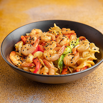 Une recette de crevettes sautées à la sauce aux huîtres servies sur des nouilles aux œufs