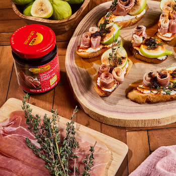 A spicy goat cheese prosciutto crostini recipe drizzled with Lee Kum Kee Chili Crisp.