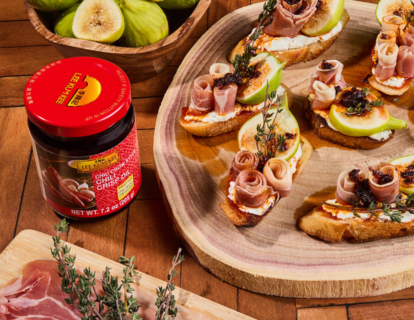 A spicy goat cheese prosciutto crostini recipe drizzled with Lee Kum Kee Chili Crisp.