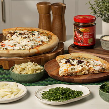A spinach artichoke pizza recipe made with the cast iron pan pizza method.