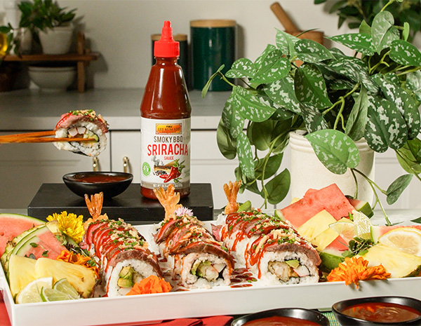 A surf and turf sushi roll platter topped with various flavors of sriracha sauce.