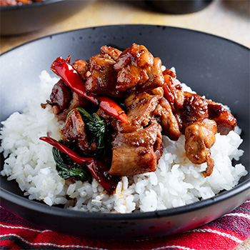  Une recette de poulet aux trois tasses, servi sur du riz.