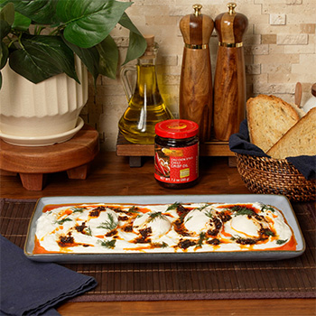 A recipe for Cilbir, or Turkish eggs, topped with Chili crisp oil.