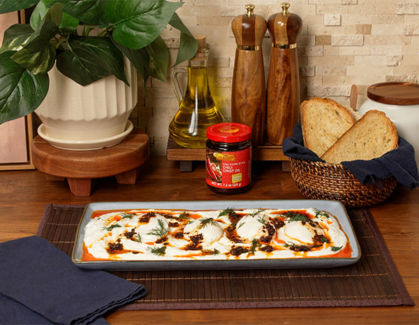 A recipe for Cilbir, or Turkish eggs, topped with Chili crisp oil.