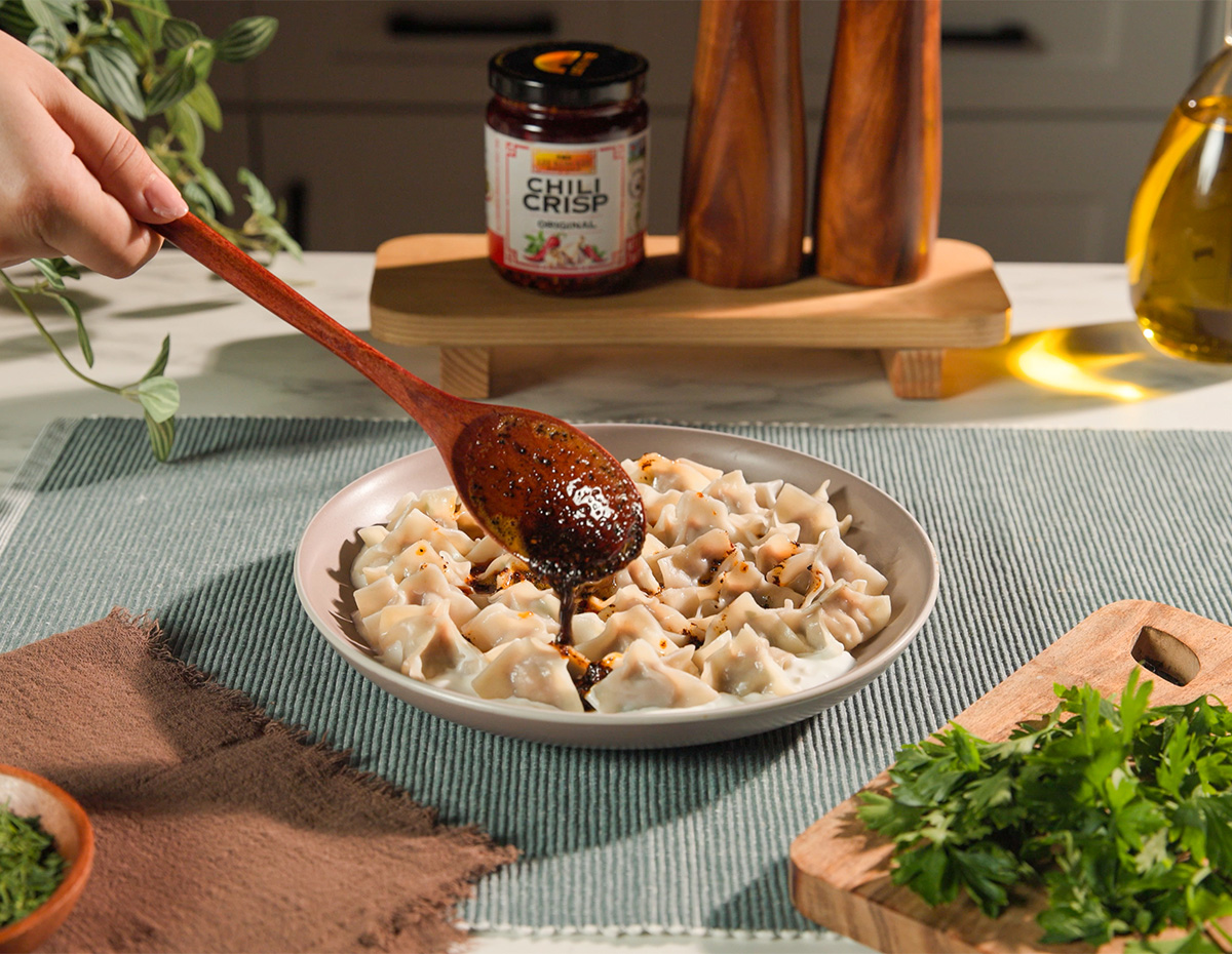 A Turkish style manti recipe topped with a chili crisp butter sauce.