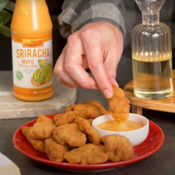 A Hand holding a golden brown chicken nugget made with Lee Kum Kee’s simple chicken nugget recipe.