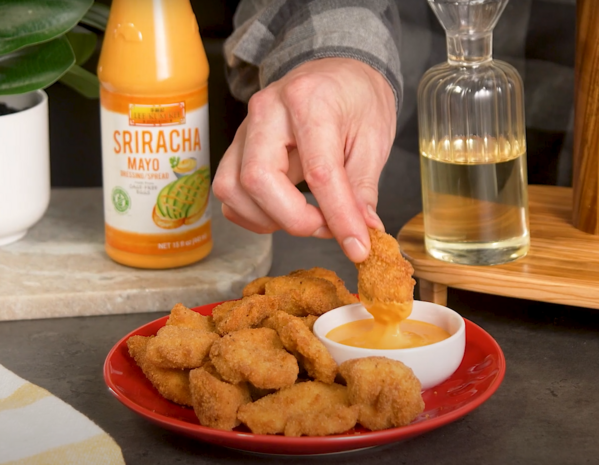 A Hand holding a golden brown chicken nugget made with Lee Kum Kee’s simple chicken nugget recipe. 