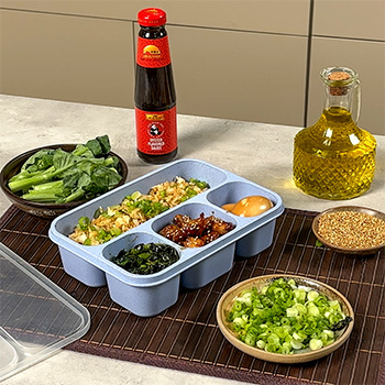 A bento lunch box recipe made with sesame chicken, quick fried rice, gai lan, and a soy marinated egg.
