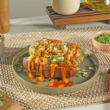 A simple buffalo chicken recipe topping a loaded baked potato.