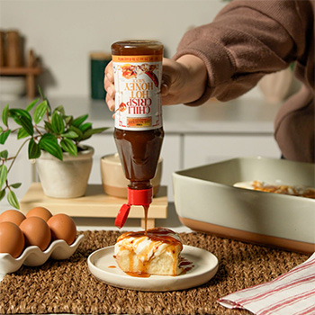 A cinnamon rolls recipe finished with chili crisp hot honey for a sweet and spicy twist.