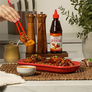 A crispy chicken dumplings recipe coated in a honey buffalo sauce and served with a ranch sriracha mayo dip.
